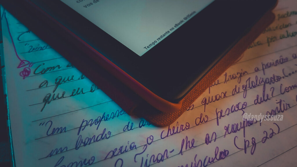 Espelho Reverso | Foto autoral do blog: Kindle indicando o tempo restante de leitura. Em cima de uma caderno com anotações | Dandy Souza